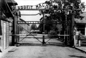 photo: Gate of Auschwitz. Over the top are the words "ARBEIT MACHT FREI"
