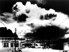 photo: a photo of the mushroom cloud rising over Nagasaki, taken from ground level in the city