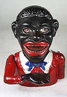 photo: Jolly Nigger Mechanical Bank. A bank shaped like a grotesque caricature of a black man's torso, with huge bright-red lips, bug-eyes, and an outstretched hand