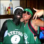 photo: two white members of the women's softball team, in blackface, posing for the camera with gold teeth flashing and hands making gang signs