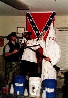 photo: white frat brothers, one dressed in Klan robes and one in blackface, stage a mock lynching. Auburn, Halloween 2001.