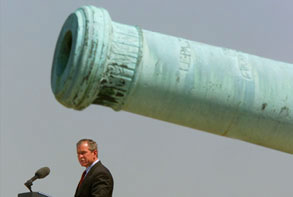 photo: George w. Bush, delivering a speech under a massive cannon