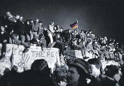 Here's a photo of Germans standing on top of the Berlin Wall as it is being torn down.