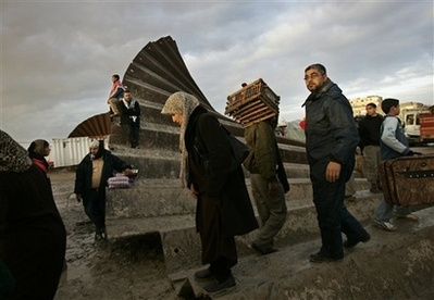 Here's a photo of Gazans stepping over a destroyed border wall.