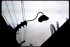 photo: Detail of a lamp over the barbed wire fence at Auschwitz
